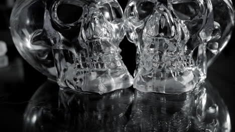 rotating scary glass skulls with black background, low dolly