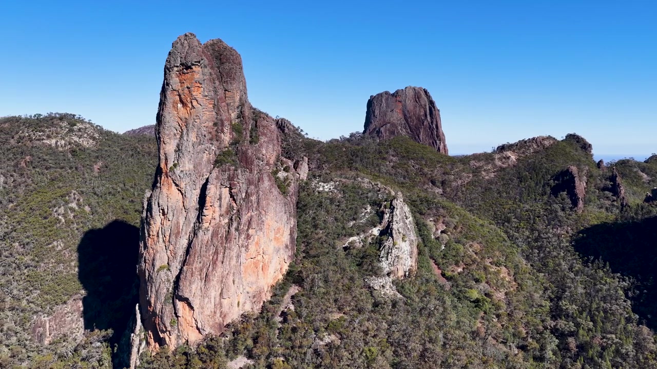 Vidt luftfoto av vulkanske plugger og ulendt fjellandskap i Warrumbungle nasjonalpark, Australia