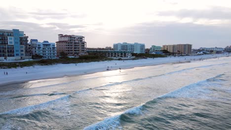 Excelente-Vista-Aérea-De-La-Gente-Caminando-Por-La-Orilla-De-La-Playa-De-New-Smyrna,-Florida