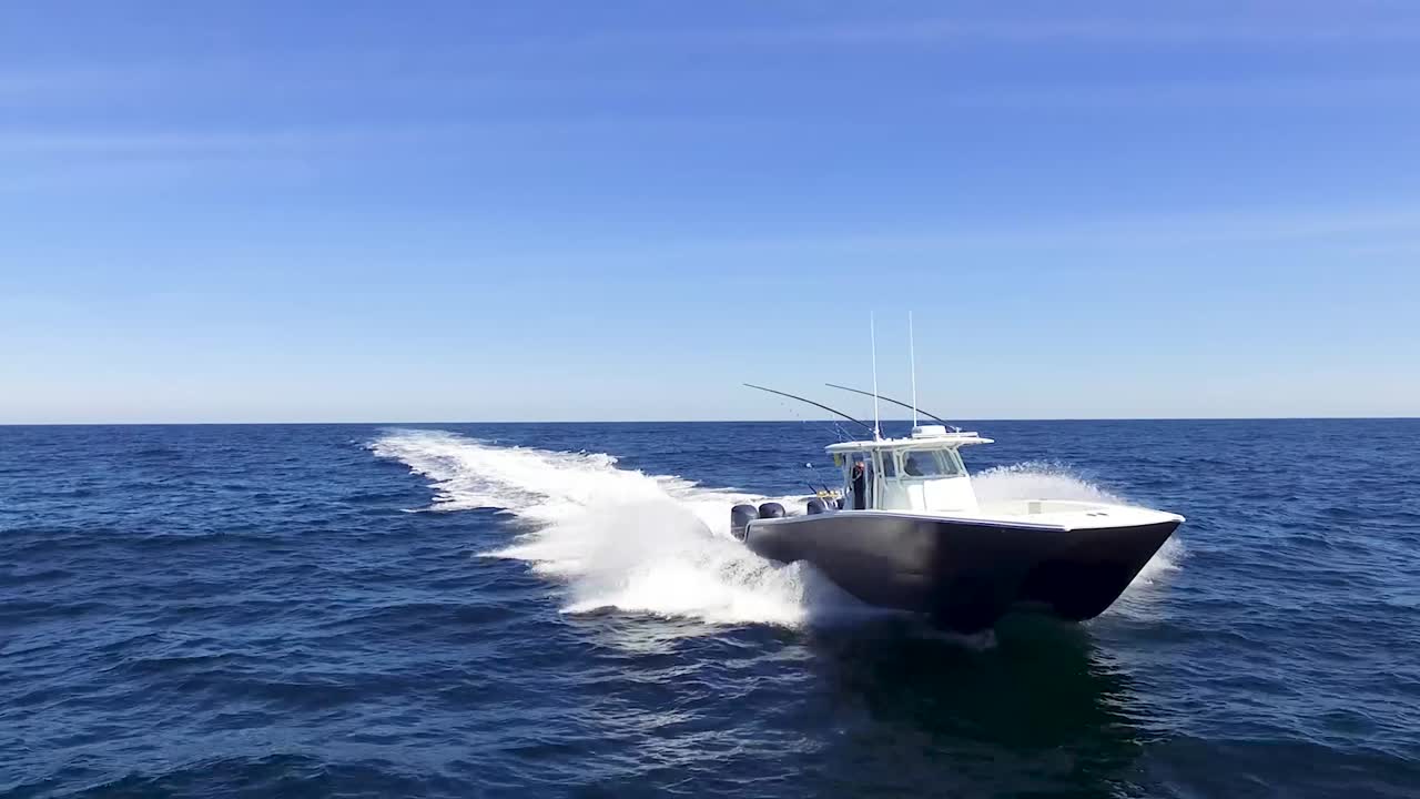 Close up view of boat riding in the open ocean on a bright sunny day with blue skies and blue ocean