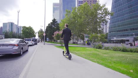 hombre de negocios montando un scooter eléctrico en la ciudad.