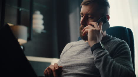 professional financial expert working on laptop, monitoring real-time stocks and exchange market charts, having phone call. successful businessman works in comfortable office of investment bank.