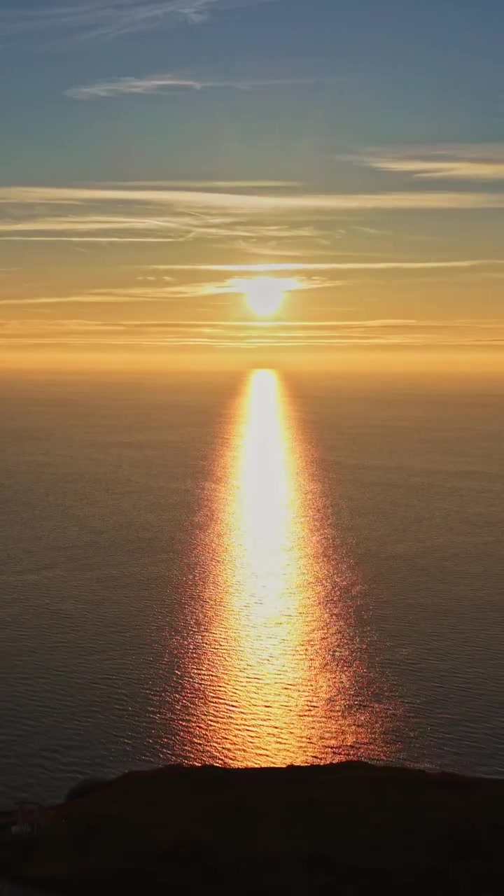 Udsigt over solnedgangen over havet med solen, der reflekteres på vandoverfladen