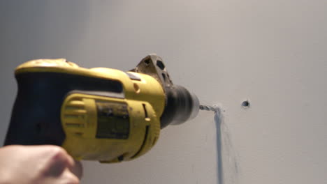 hombre perfora una pared para colgar pintura o escultura de arte