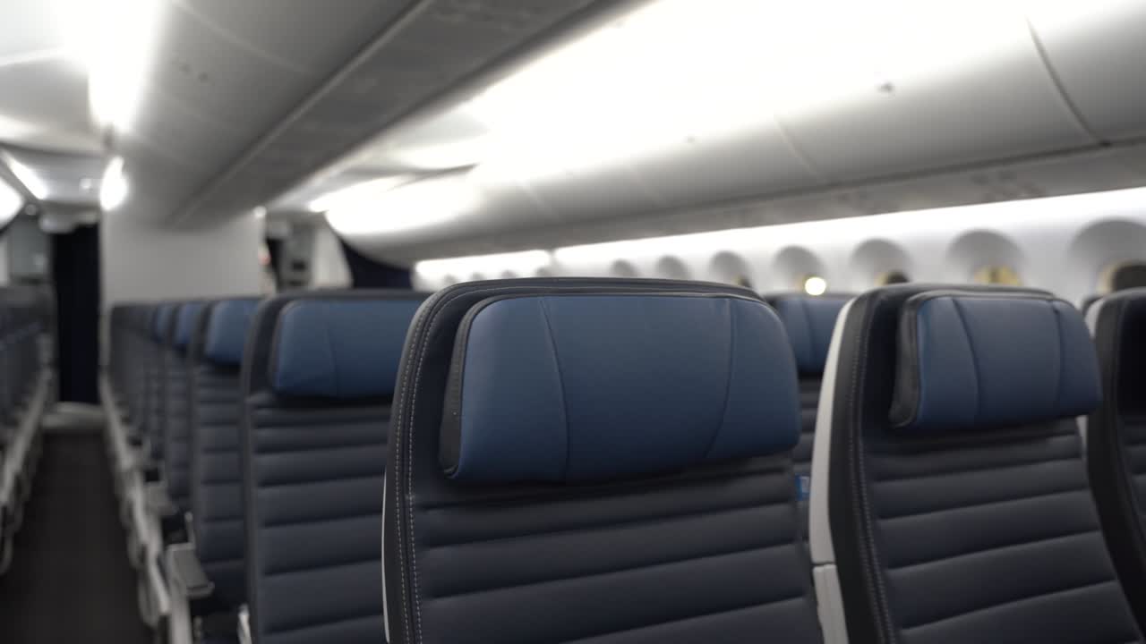 dolly en filas de asientos de avión de cuero azul vacío.