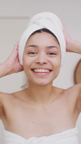 video vertical del retrato de una mujer biracial con una toalla sonriendo