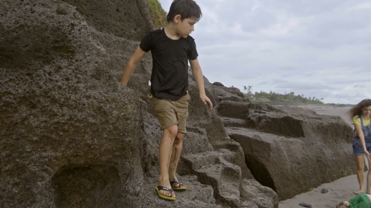 niño de escuela primaria explorando la playa