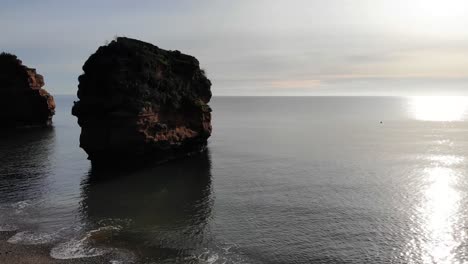 Tiro-De-Paralaje-Lento-De-Una-Pila-De-Arenisca-En-El-Mar-Frente-A-La-Hermosa-Bahía-De-Ladram-Inglaterra-Al-Atardecer