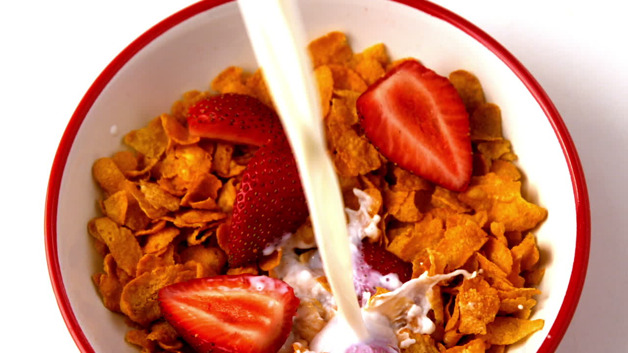 딸기 와 함께 시리얼 의 그 위 에 우유 를 부어 놓는 것