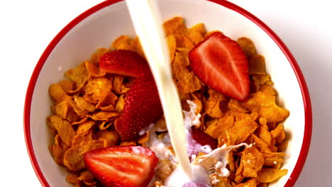 Milch-über-Eine-Schüssel-Müsli-Mit-Erdbeeren-Gießen