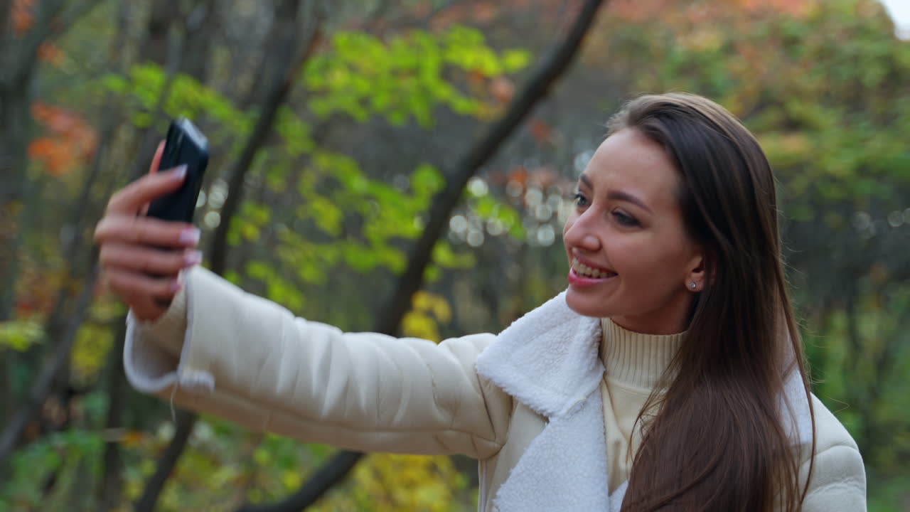 Woman taking a selfie in an autumn park
