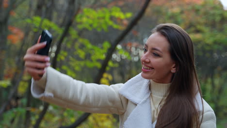 woman taking a selfie in an autumn park