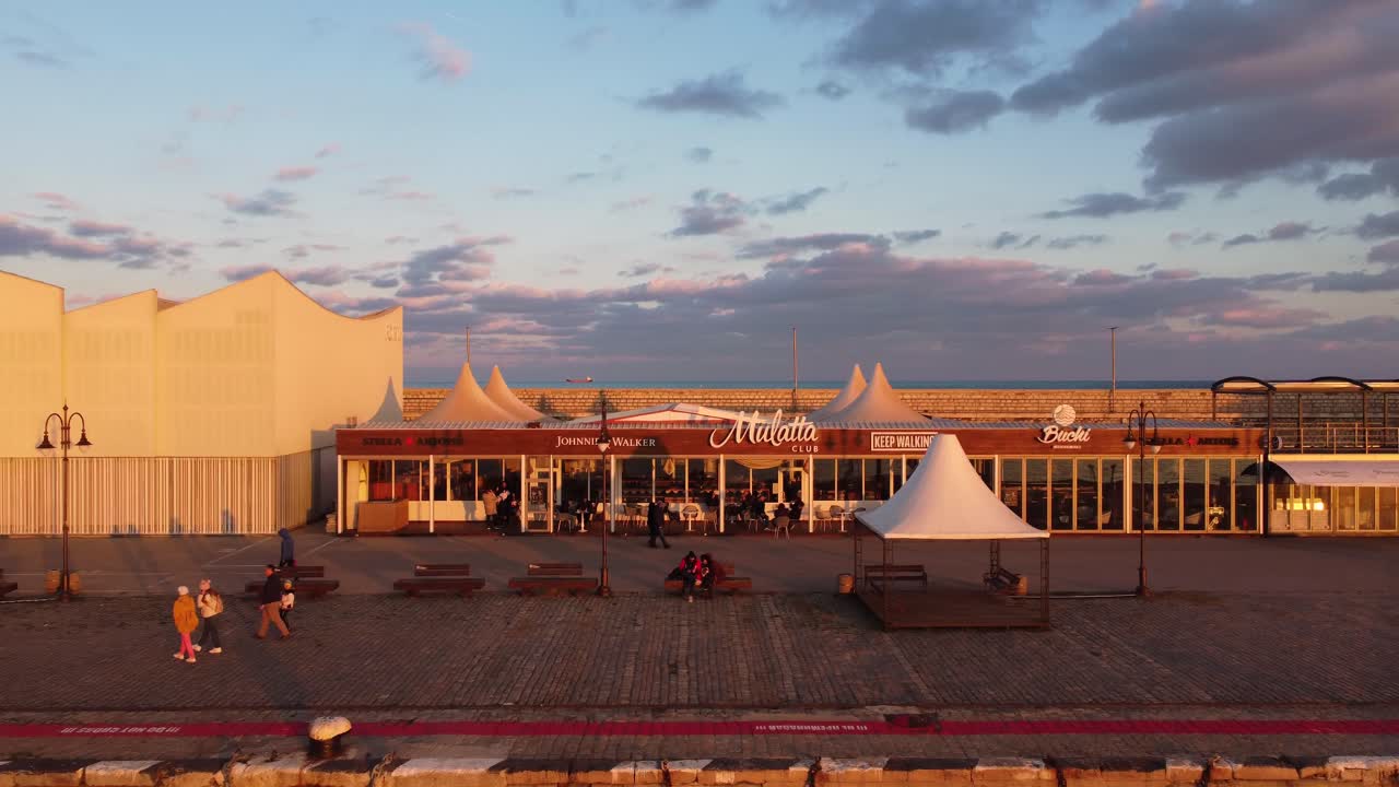 drone flyver mod den brune bygning af klubben på havnen i varna pier med folk, der går foran