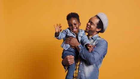 African-american-young-dad-hugging-his-sweet-little-son-and-playing-with-him