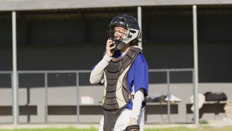 disappointed caucasian female baseball player, taking off helmet and walking off field after game