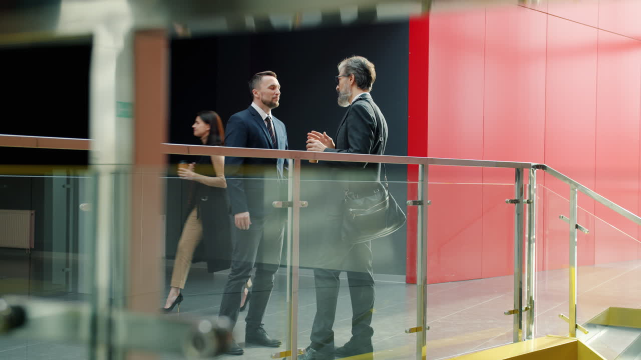 Businessmen in Conversation in Modern Office Corridor