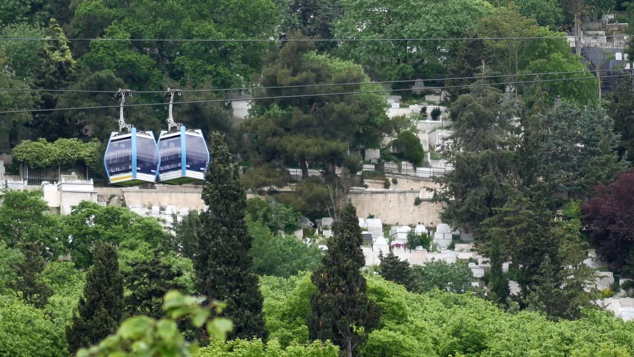 viaje en teleférico por un cementerio en la ladera de una colina