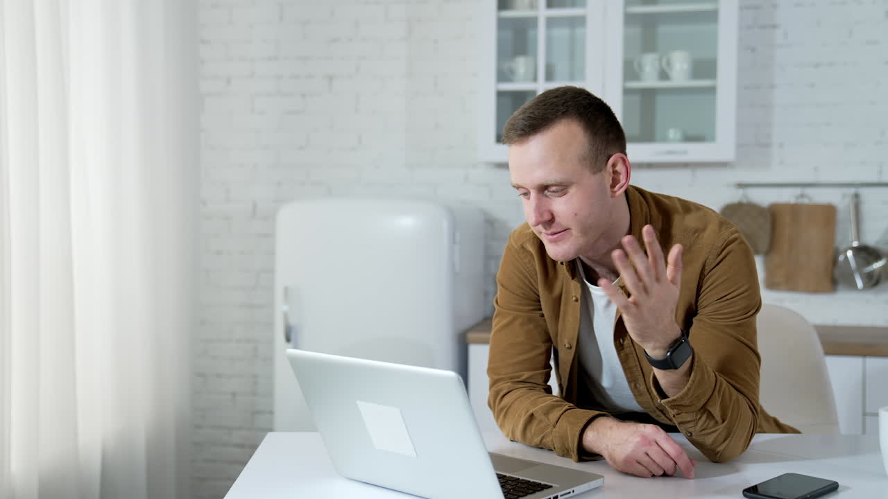 Happy businessman talking on video conference online at home. Male professional explaining project with gestures at remote workplace