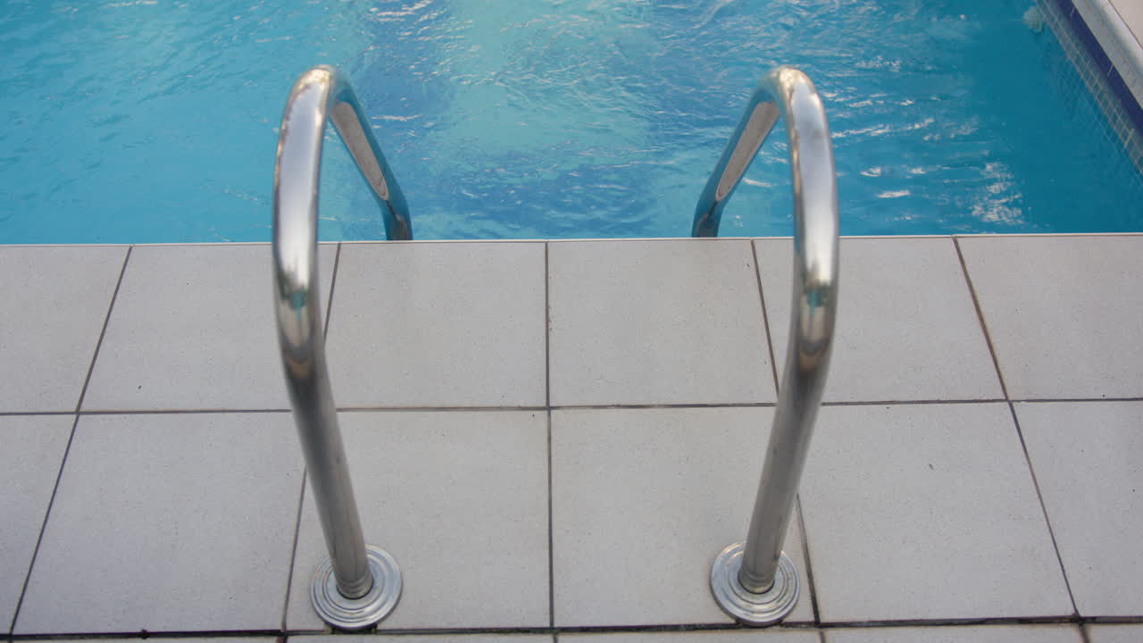 Poolstige med blåt vand i baggrunden