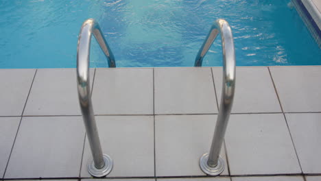 pool ladder with blue water in the background