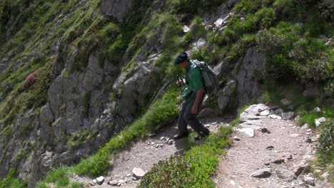 un hombre camina por una montaña con una mochila