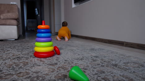 toddler crawling and playing with stacking rings
