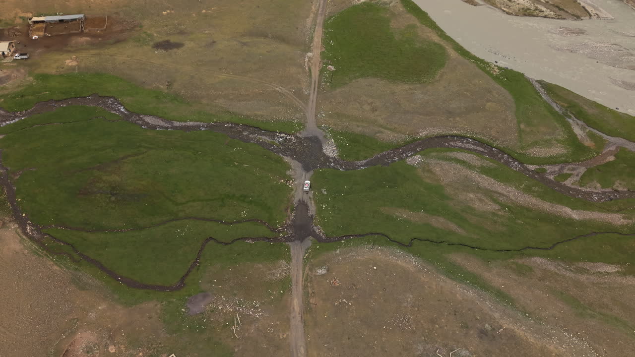 Above View Of A Vehicle In Remote River Mountain In Kyrgyzstan, Central Asia. Aerial Drone Shot
