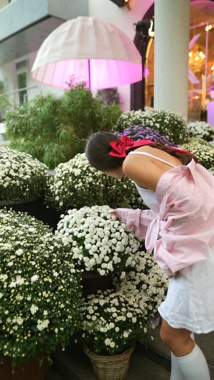mujer admirando flores fuera de una tienda