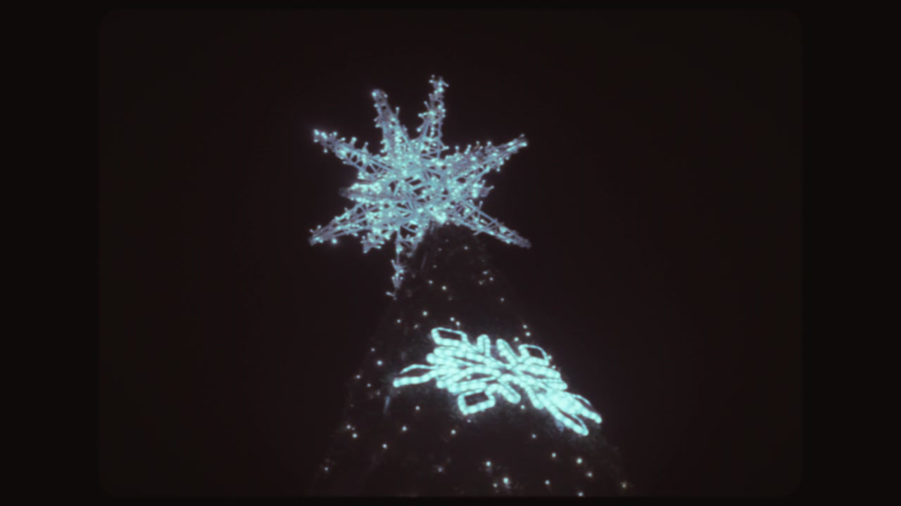 Glowing Christmas star on a tree outside at night