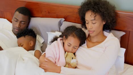 Vista-Frontal-De-Una-Familia-Negra-Durmiendo-En-El-Dormitorio-De-Casa-4k