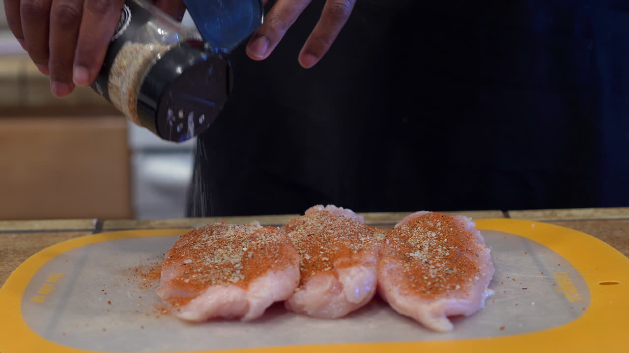 뼈와 껍질을 제거한 닭가슴살 필레에 홈메이드 드라이 럽을 위한 향신료와 허브 추가