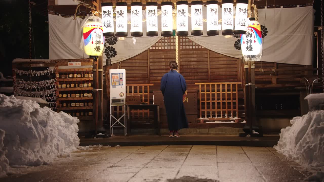 Santuario giapponese con donna in Yukata in preghiera, lanterne di notte, Kinosaki Onsen