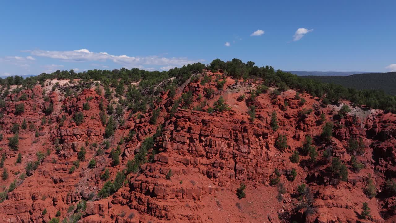Close aerial approach to rugged red cliffs at Mushroom Rock with vivid tones and deep textures, Carbondale Colorado