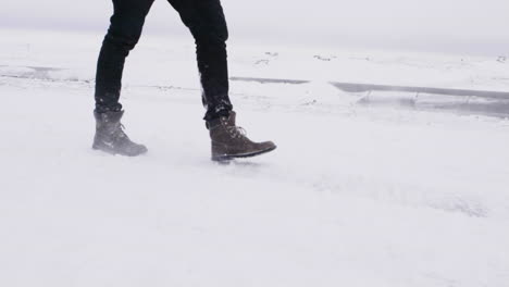 young male traveler walking through blizzard in slow motion