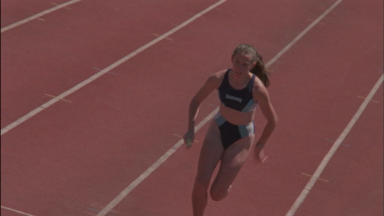 una corredora pasa el testigo en una carrera de relevos