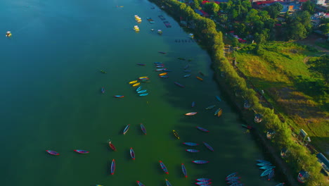 Die-Drohnenaufnahme-Fängt-Die-Atemberaubende-Aussicht-Auf-Boote-Ein,-Die-Im-Phewa-See-Treiben,-Und-Enthüllt-Gleichzeitig-Das-Atemberaubende-Panorama-Der-Stadt-Pokhara,-Des-Seeufers-Sowie-Der-Majestätischen-Bergketten-Macchapuchhre-Und-Annapurna