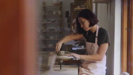 young female potter working in her studio