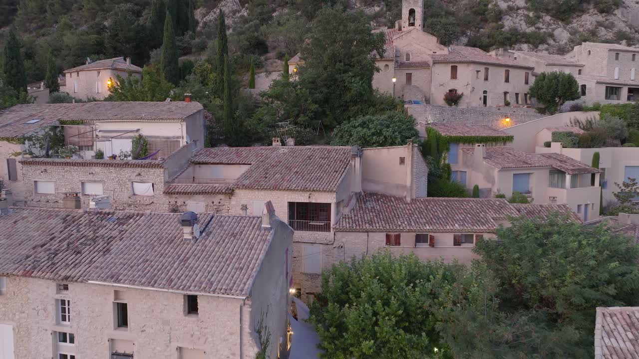 Ripresa aerea con drone della città medievale di Séguret, Vaucluse, Provenza, con vigneti al tramonto in Francia