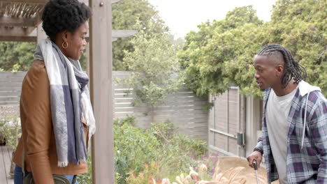 talking in garden, african american couple enjoying conversation in backyard with greenery