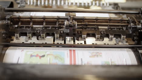 Moving-parts-on-the-printing-machine,-printed-pages-traveling-through-the-rollers