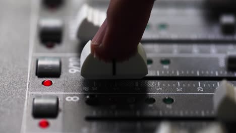 el dedo índice de la persona deslice el fader hasta el volumen máximo de la mesa de mezclas