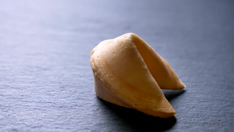 primer plano en círculo alrededor de la toma de la galleta con la predicción girando lentamente en el fondo de la mesa gris.