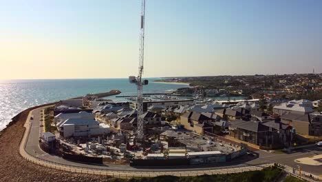 new coastal housing development with crane in mindarie, australia at sunset by the ocean