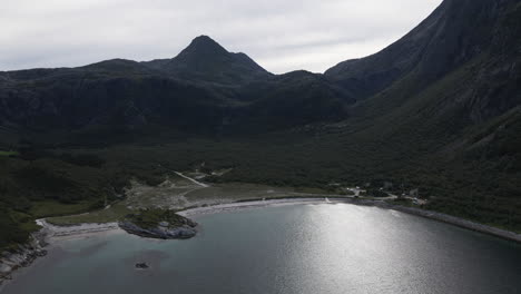 mountain landscape and tranquil beach in breivika, dønna, norway - aerial drone shot