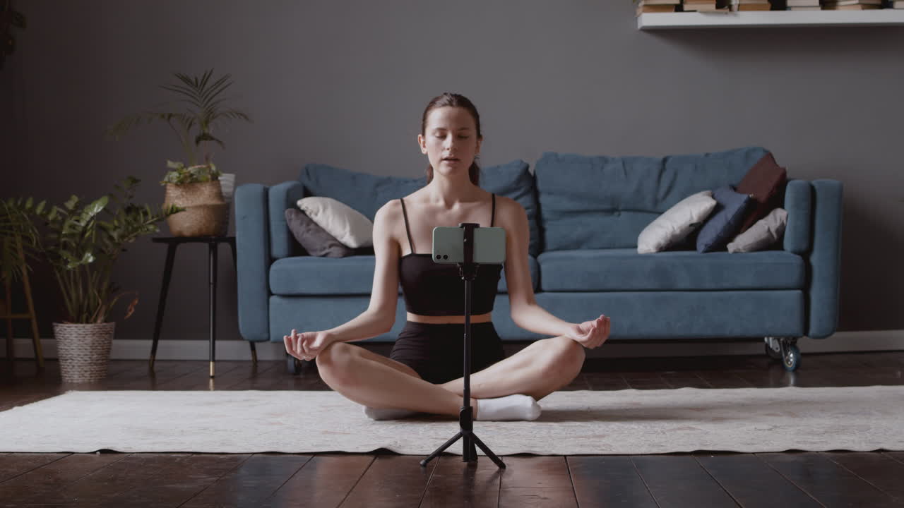 linda jovencita diciendo namaste a sus seguidores y dando una clase de yoga en línea
