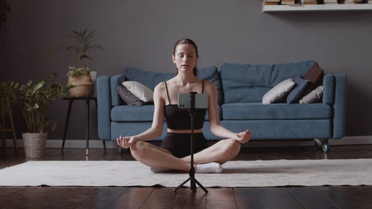 Giovane ragazza carina che dice Namaste ai suoi follower e tiene una lezione di yoga online.