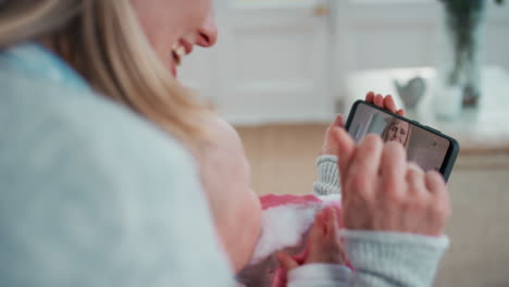 mother-and-baby-using-smartphone-having-video-chat-with-best-friend-waving-at-toddler-happy-mom-chatting-sharing-motherhood-lifestyle-on-mobile-phone