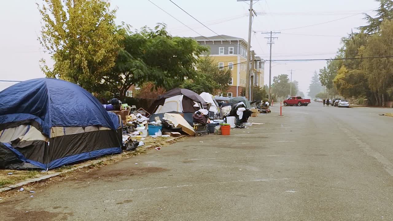 Accampamento abusivo di tende di senzatetto su strade cosparse di rifiuti