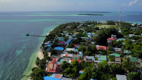 flying over several humble buildings in a local island in the maldives