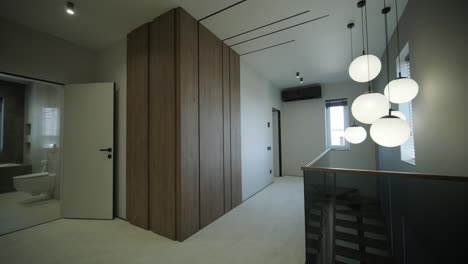 modern hallway with pendant lighting and wood paneling